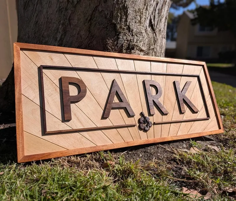 Dimensional walnut PARK lettering on a maple panel with hibiscus detail